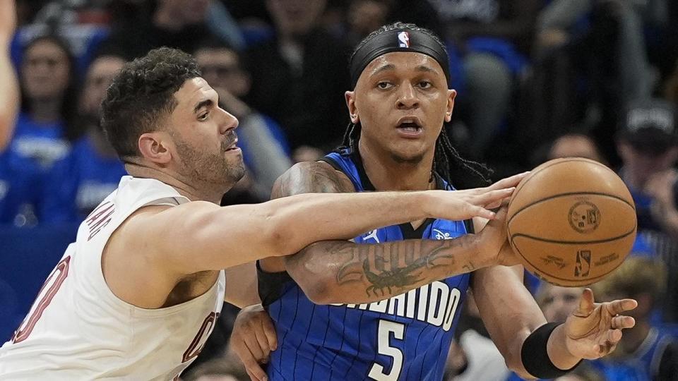 Georges Niang (left) tries to block Orlando forward Paolo Banchero.