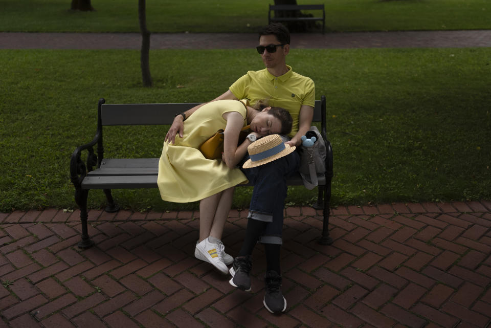 A woman takes a nap on the lap of her husband on a bench at Saint Sophia Cathedral in Kyiv, Ukraine, Sunday, July 30, 2023. (AP Photo/Jae C. Hong, File)