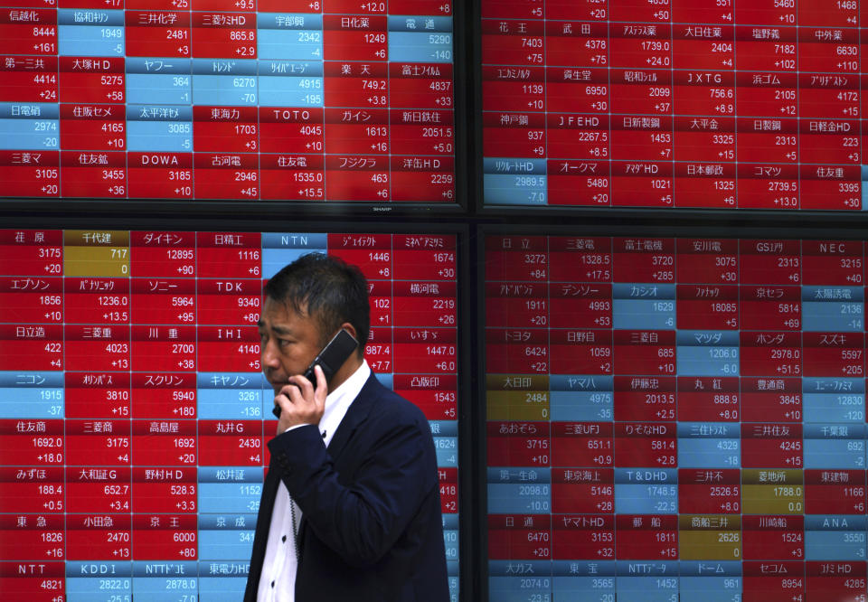 A man walks past an electronic stock board showing Japan's Nikkei 225 index at a securities firm in Tokyo Friday, Oct. 26, 2018. Asian shares were mostly higher Friday, cheered by a jump on Wall Street as strong earnings reports from market bellwethers like Microsoft and Comcast gave a confidence boost to investors shaken by the recent wave of selling. (AP Photo/Eugene Hoshiko)