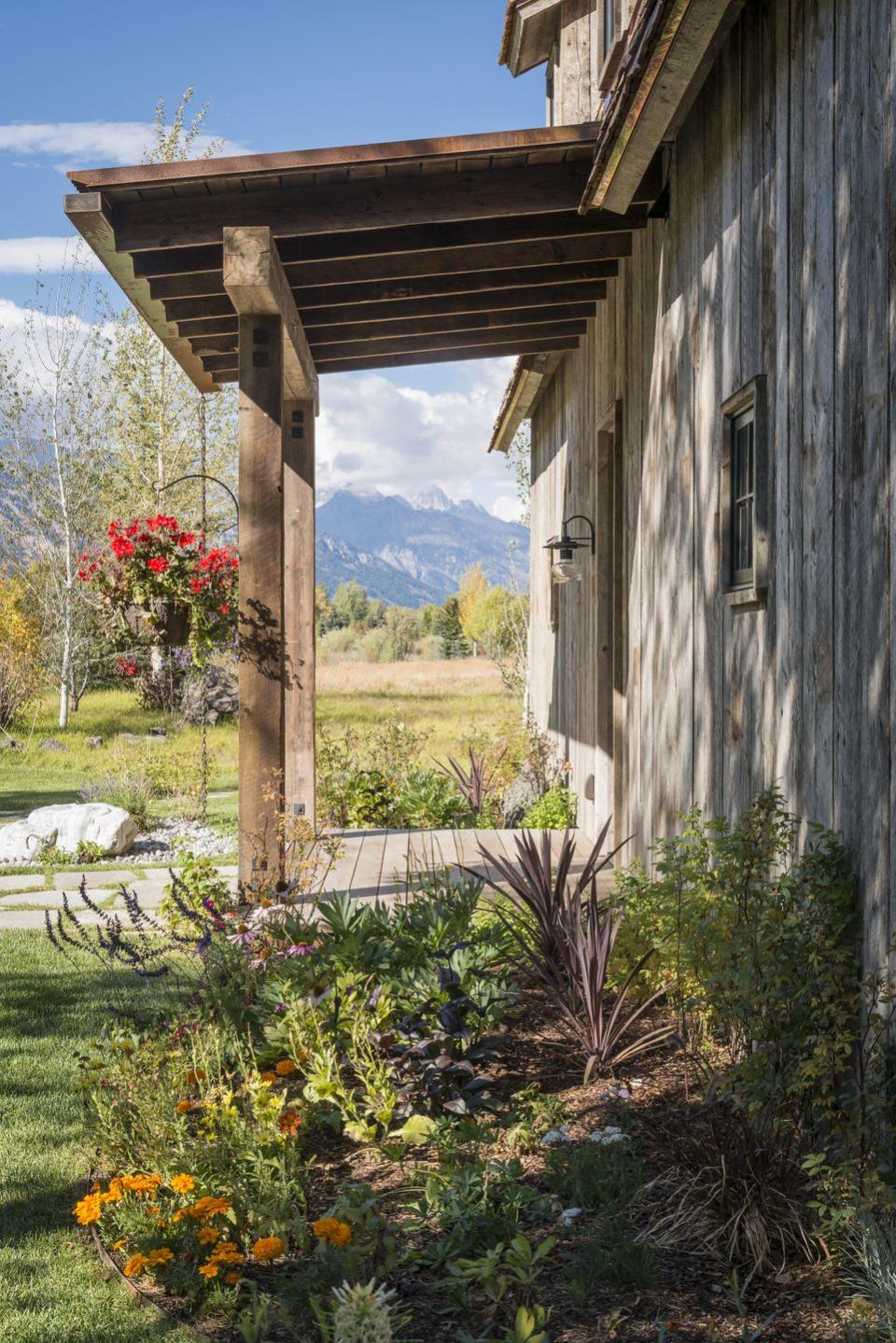 <p>Flower beds bursting with a variety of textures and colors add interest to this rustic barn-turned-guest house, while hanging flower pots anchor the porch.</p><p><strong><a href="https://www.countryliving.com/home-design/a41453/rustic-barn-inspired-guest-house/" rel="nofollow noopener" target="_blank" data-ylk="slk:Read more about this rustic barn-turned-guest house;elm:context_link;itc:0;sec:content-canvas" class="link ">Read more about this rustic barn-turned-guest house</a>.</strong></p><p><a class="link " href="https://go.redirectingat.com?id=74968X1596630&url=https%3A%2F%2Fwww.etsy.com%2Fsearch%3Fref%3Dtab_search%26q%3Dhanging%2Bflower%2Bpots&sref=https%3A%2F%2Fwww.countryliving.com%2Fgardening%2Fgarden-tours%2Fg1432%2Flandscaping-ideas%2F" rel="nofollow noopener" target="_blank" data-ylk="slk:SHOP HANGING POTS;elm:context_link;itc:0;sec:content-canvas">SHOP HANGING POTS</a></p>