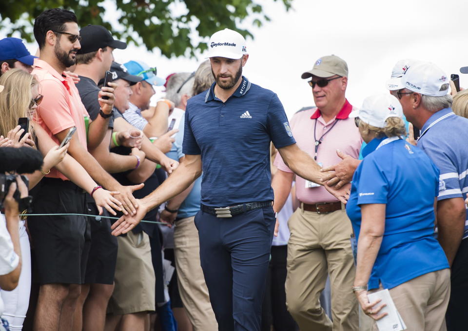 Dustin Johnson greets fans as he walks onto the first hole during the final round of the Canadian Open golf tournament at the Glen Abbey Golf Club in Oakville, Ontario, Sunday, July 29, 2018. (Nathan Denette/The Canadian Press via AP)