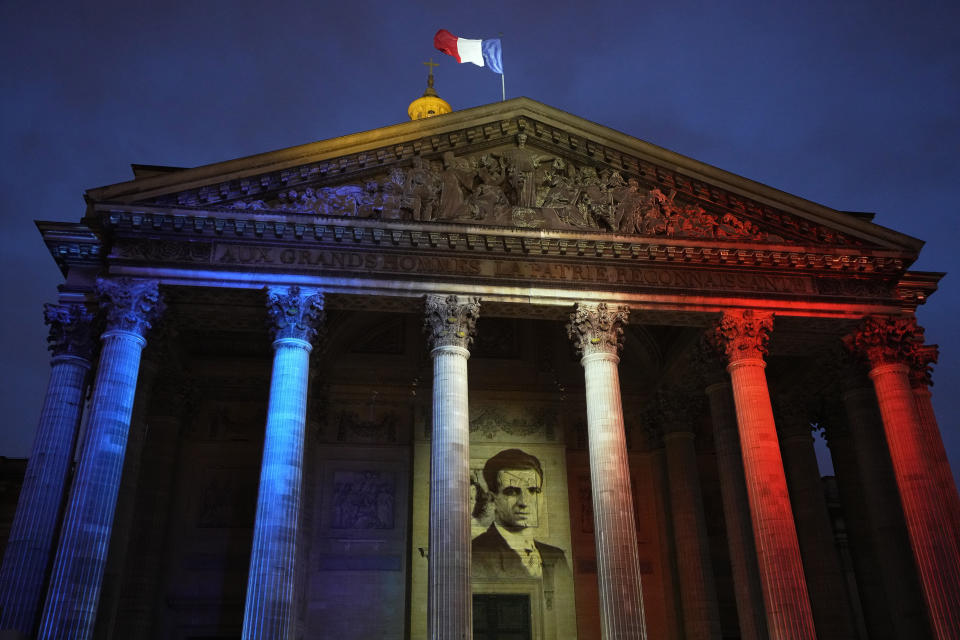 The portrait of Missak Manouchian is projected on the facade of Pantheon monument, Wednesday, Feb. 21, 2024 in Paris. While France hosts grandiose ceremonies commemorating D-Day, Missak Manouchian and his Resistance fighters' heroic role in World War II are often overlooked. French President Emmanuel Macron is seeking to change that by inducting Manouchian into the Panthéon national monument. (AP Photo/Michel Euler)