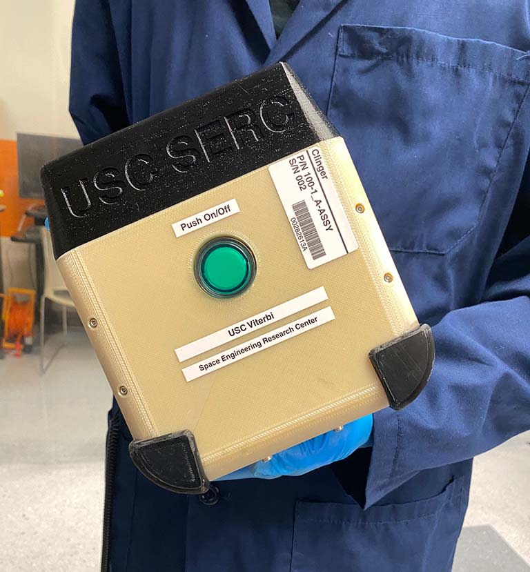 a person in a lab coat holds a small cube