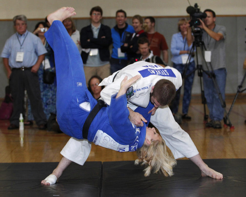 2010 world champion Kayla Harrison (L) is thrown onto the mat by 2008 Olympian Travis Stevens (R) during a judo demonstration at the U.S. Olympic Committee Media Summit in Dallas, Texas May 13, 2012. REUTERS/Tim Sharp