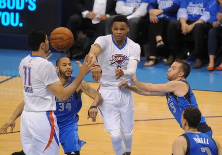 Apr 25, 2016; Oklahoma City, OK, USA; Oklahoma City Thunder guard Russell Westbrook (0) passes the ball between Dallas Mavericks guard Devin Harris (34) and Dallas Mavericks guard J.J. Barea (5) during the second quarter in game five of the first round of the NBA Playoffs at Chesapeake Energy Arena. Mark D. Smith-USA TODAY Sports