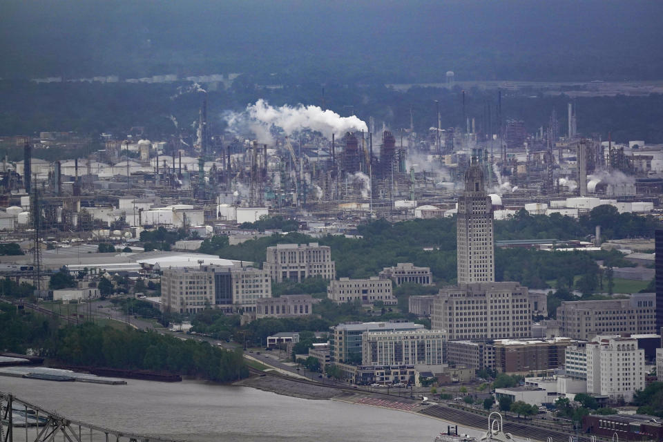 The Exxon Mobil Baton Rouge Refinery complex is visible with the Louisiana State Capitol, bottom right, in Baton Rouge, La., Monday, April 11, 2022. Exxon Mobil’s scientists were remarkably accurate in their predictions about global warming, even as the company made public statements that contradicted its own scientists' conclusions, a new study says. (AP Photo/Gerald Herbert)