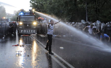 A riot police vehicle sprays jets of water to disperse protesters during a rally against a recent decision to increase the tariff on electricity, in Yerevan, Armenia, June 23, 2015. REUTERS/Narek Aleksanyan/PAN Photo