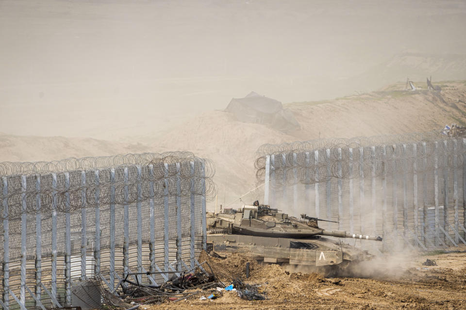 Israeli soldiers drive a tank as they cross the border from inside Gaza Strip in to southern Israel, Tuesday, Feb. 13, 2024. The army is battling Palestinian militants across Gaza in the war ignited by Hamas' Oct. 7 attack into Israel. (AP Photo/Ariel Schalit)