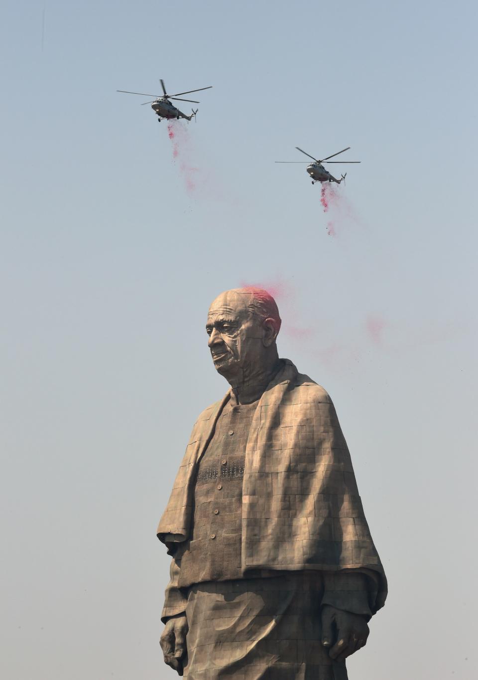 Indian Air Force helicopters shower rose petals on the Statue Of Unity in India.