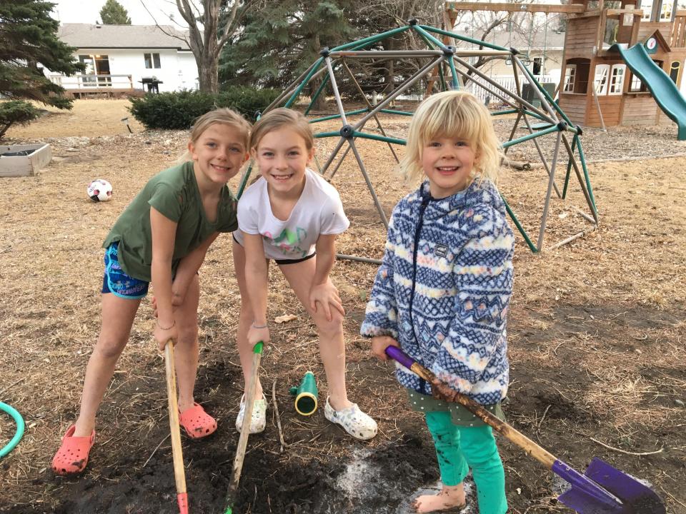 Three young girls playing outside together.