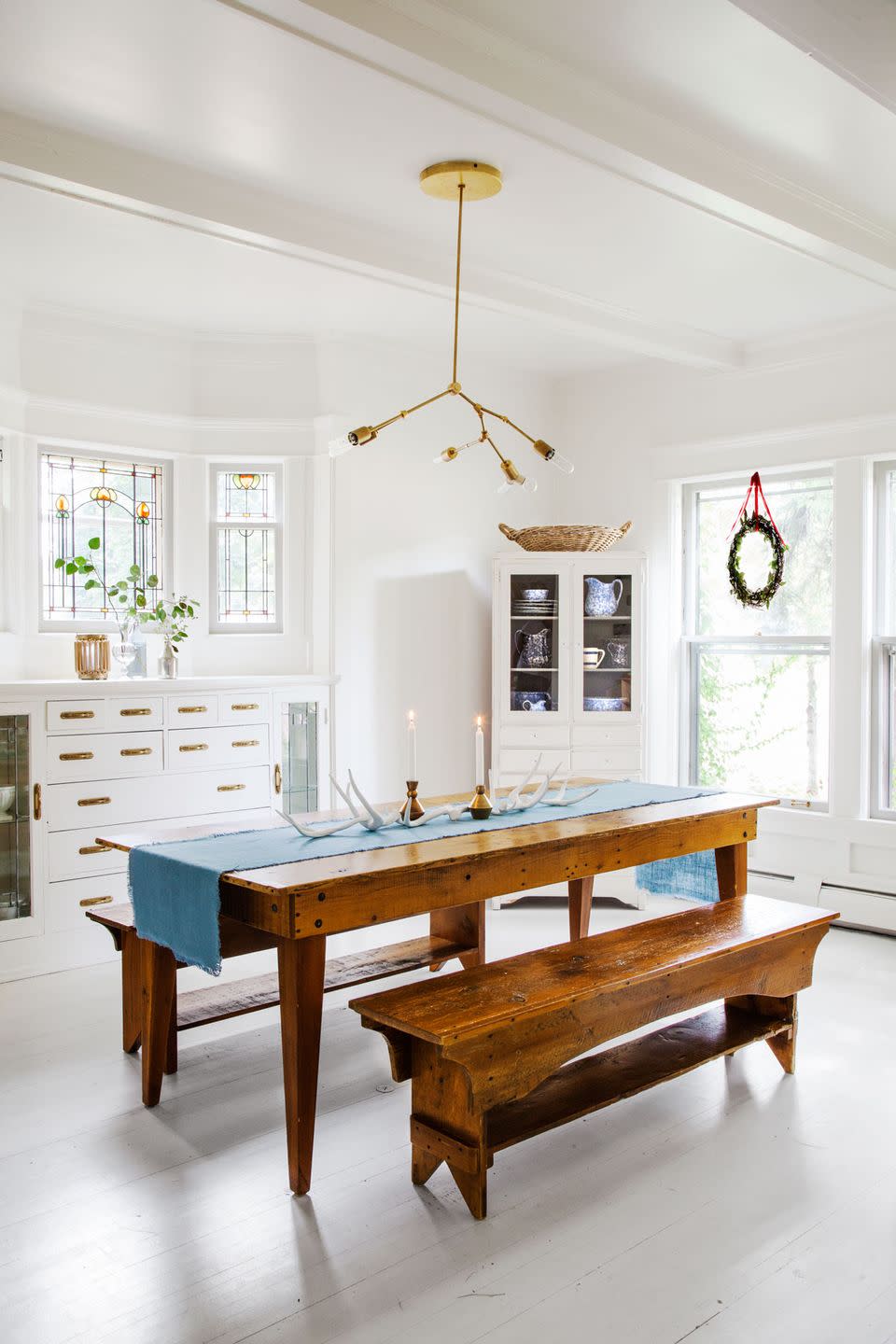 <p>This designer keeps the dining room table in her <a href="https://www.countryliving.com/home-design/house-tours/g2780/jennaea-gearhart-white-christmas-decor/" rel="nofollow noopener" target="_blank" data-ylk="slk:historic Tudor house;elm:context_link;itc:0;sec:content-canvas" class="link ">historic Tudor house</a> simple for the season with a blue runner, brass candle holders, and antlers. </p><p><a class="link " href="https://www.amazon.com/Solino-Home-Linen-Table-Runner/dp/B09QKQDFW7/ref=sr_1_2_sspa?tag=syn-yahoo-20&ascsubtag=%5Bartid%7C10050.g.644%5Bsrc%7Cyahoo-us" rel="nofollow noopener" target="_blank" data-ylk="slk:Shop Now;elm:context_link;itc:0;sec:content-canvas">Shop Now</a></p>