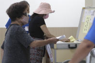 Members of the Nationalist Party, or KMT, cast their ballot for election of its party chairman at a polling station in Taipei, Taiwan, Saturday, Sept. 25, 2021. Fraught relations with neighboring China are dominating Saturday's election for the leader of Taiwan’s main opposition Nationalist Party. (AP Photo/Chiang Ying-ying)