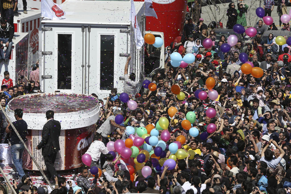 5-tons of ice-cream, left, made by Iranian Choopan dairy is displayed during a ceremony at the Tochal mountainous area of northern Tehran, Iran, Monday, April 1, 2013. Choopan dairy unveiled a 5-tons chocolate icecream, the largest in the world, according to the factory officials. (AP Photo/Ebrahim Noroozi)