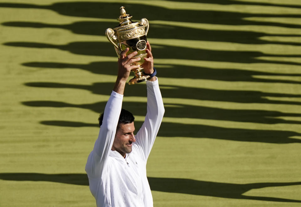 Serbia's Novak Djokovic celebrates with the trophy after beating Australia's Nick Kyrgios in the final of the men's singles on day fourteen of the Wimbledon tennis championships in London, Sunday, July 10, 2022. (AP Photo/Gerald Herbert)
