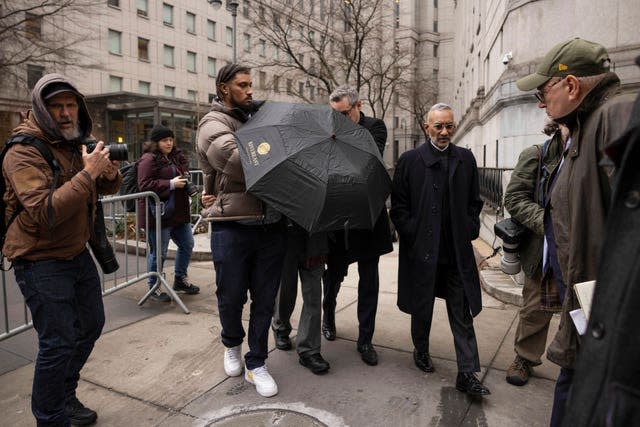 Joe Lewis leaves the court behind an umbrella 