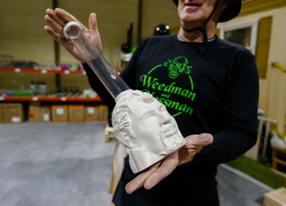 Joesph Spina, co-owner of Weedman and Glassman in Bolivar, shows off a 3d-printed bong in the shape of a head on Friday Feb. 3, 2023.