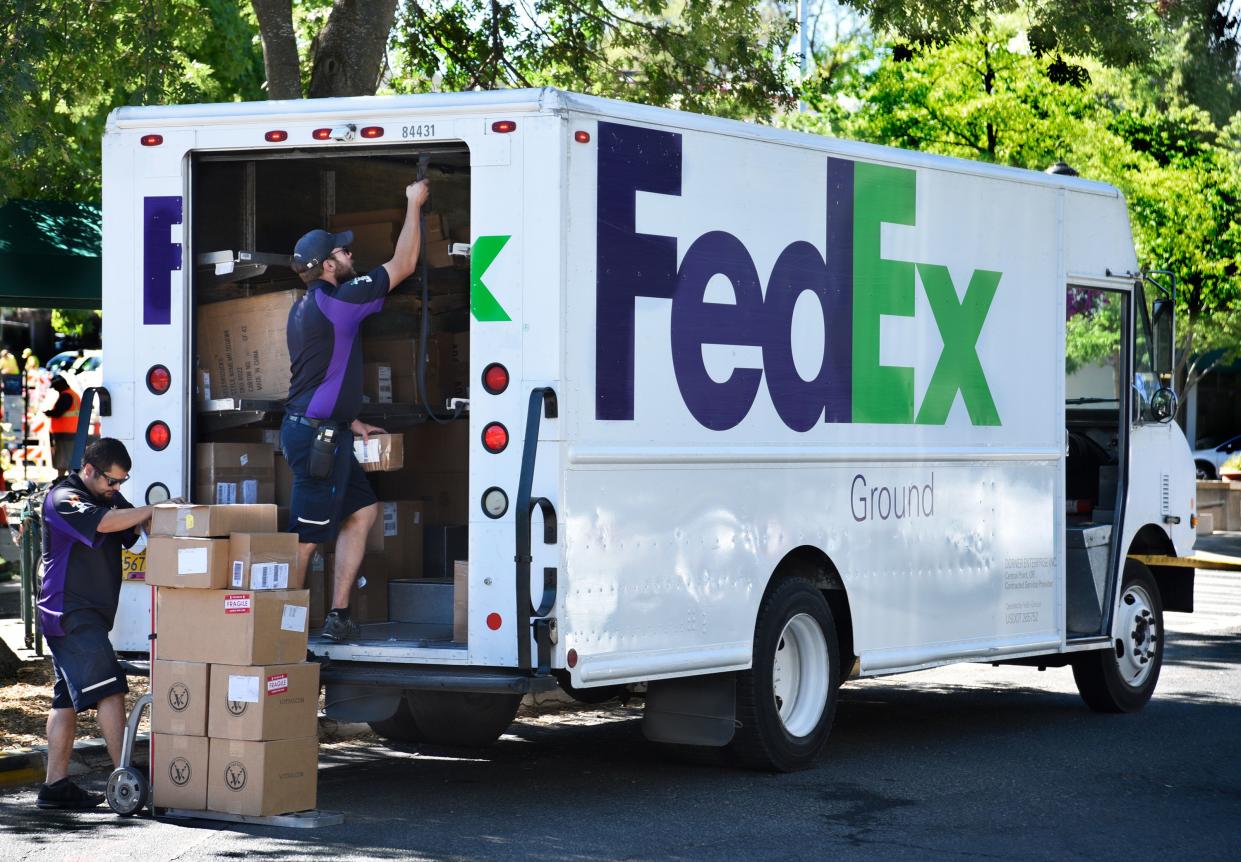 Federal Express (FedEx) deliverymen unload packages to be delivered in Ashland, Oregon.