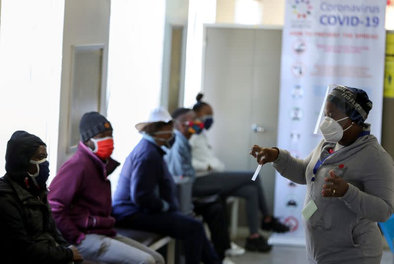 FILE PHOTO: A medical worker talks to volunteers as they wait to receive an injection during the country's first human clinical trial for a potential vaccine against the novel coronavirus, in Soweto