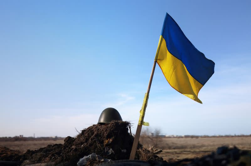 FILE PHOTO: A Ukrainian flag and a helmet of a soldier are pictured at checkpoint, as Russia's invasion of Ukraine continues, in Mykolaiv