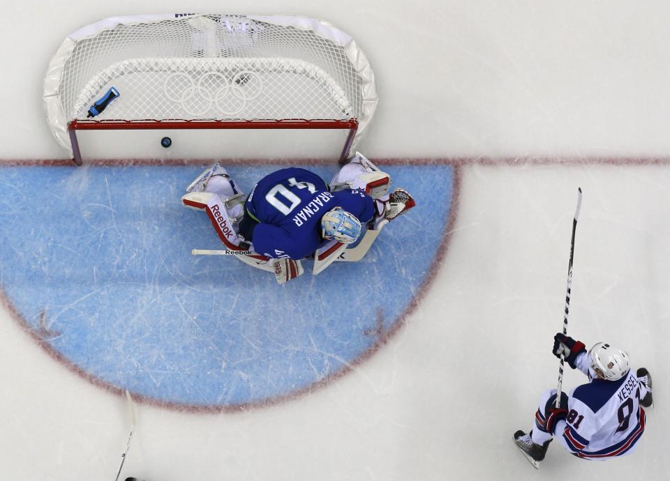 Team USA's Phil Kessel scores a goal on Slovenia's goalie Luka Gracnar during the first period of their men's preliminary round ice hockey game at the 2014 Sochi Winter Olympics, February 16, 2014. REUTERS/Brian Snyder (RUSSIA - Tags: OLYMPICS SPORT ICE HOCKEY TPX IMAGES OF THE DAY)