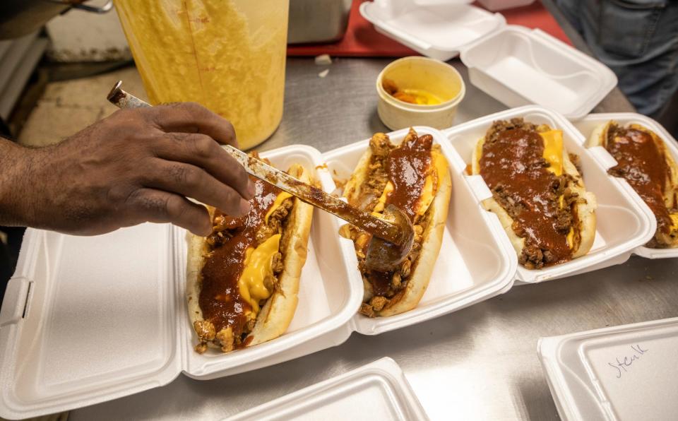 Greg Beard, 62, chef and owner of Soul-N-The Wall, pours sauce on top of an order of Boogaloo sandwiches that he delivers to the Detroit Fire Department for free inside the restaurant's kitchen in Detroit on Wednesday, June 21, 2023.