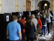 FILE- In this Tuesday, Sept. 19, 2017 file photo, people line up to cast their votes at a polling station for the absentee vote in Berlin, Germany. German voters elect a new parliament on Sunday, Sept. 26, 2021, a vote that will determine who succeeds Chancellor Angela Merkel after her 16 years in power. (AP Photo/Markus Schreiber, File)