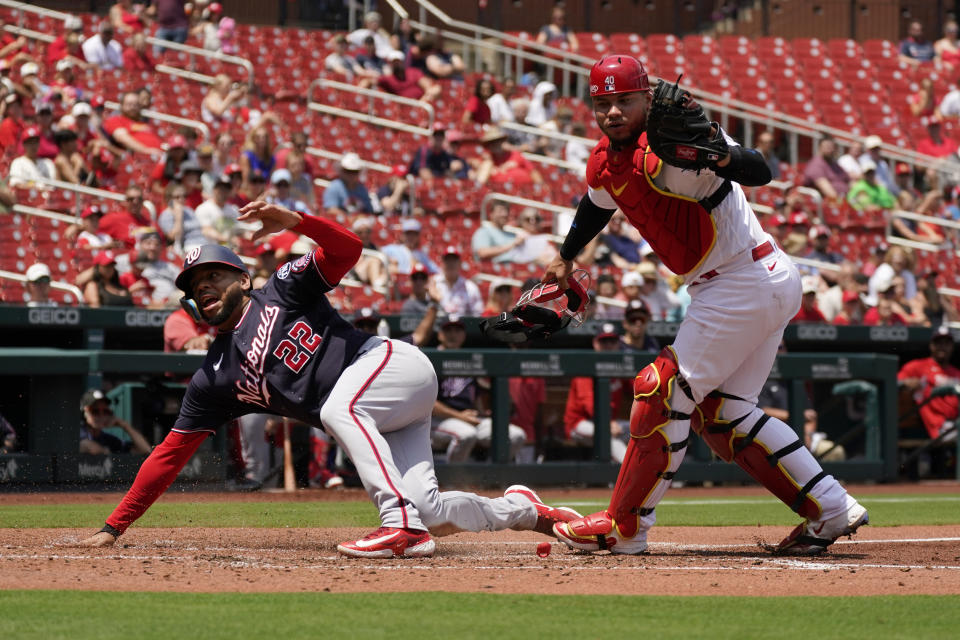 Washington Nationals' Dominic Smith (22) is safe after scoring ahead of the tag from St. Louis Cardinals catcher Willson Contreras during the fifth inning in the first game of a baseball doubleheader Saturday, July 15, 2023, in St. Louis. The contest was the resumption of a game started on Friday, but was suspended due to rain. (AP Photo/Jeff Roberson)