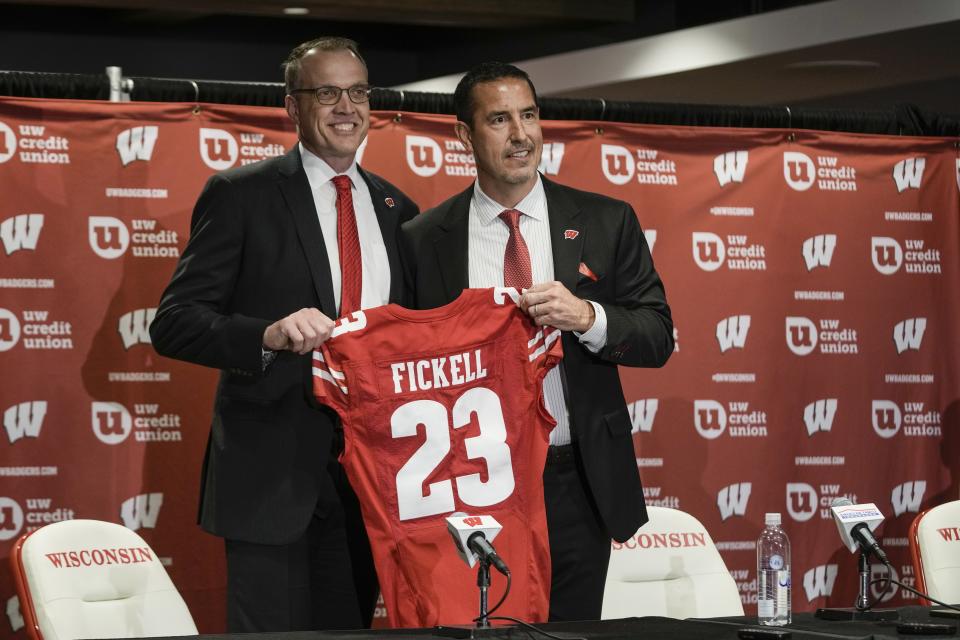 Wisconsin athletic director Chris McIntosh, left, introduces new head football coach Luke Fickell at a news conference Monday, Nov. 28, 2022, in Madison, Wis. (AP Photo/Morry Gash)