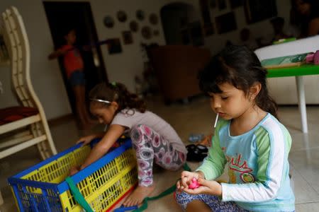 Renata Bonilla (R), plays with her cousins at their grandmother's house on a day of protests in Caracas, Venezuela June 14, 2017. REUTERS/Carlos Garcia Rawlins