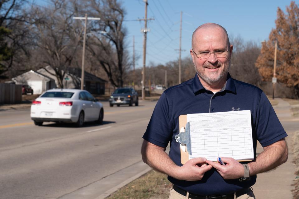 Earl McIntosh poses with a stack of petitions that call for the passage of a proposed ordinance that would ban Topeka's city government, without a public vote, from collecting more property taxes in any given year than it collected the previous year.