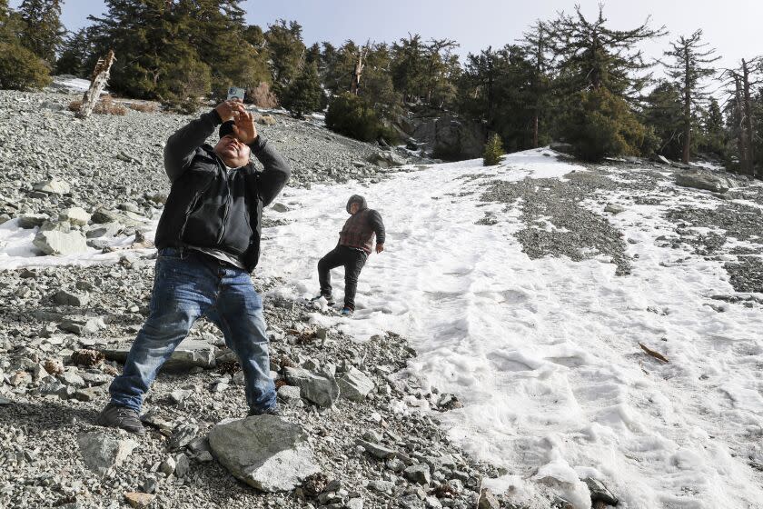 Mt. Baldy, CA, Thursday, February 16, 2023 - Marco Martinez Morales snaps a photo with his son, Marco Jr. as they frolic on a snowy roadside near Mt. Baldy. (Robert Gauthier/Los Angeles Times)