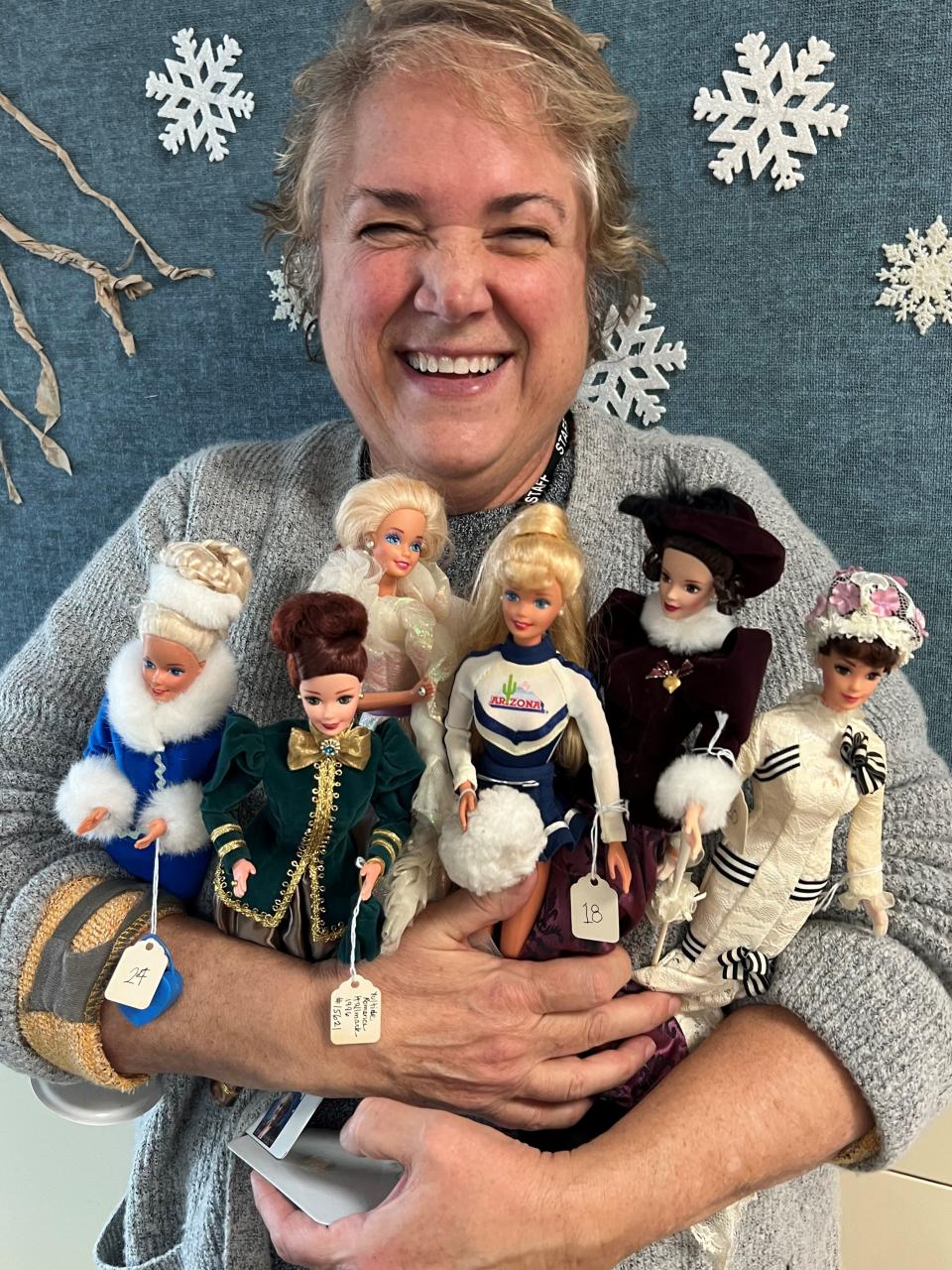 Carrie Cavanaugh, director of the Center for Active Adults in South Lyon, holds numerous Barbie dolls donated to the center. The dolls are among more than 300 the center will auction in February.