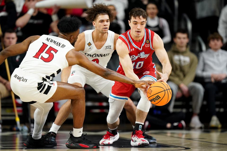 Bradley Braves guard Connor Hickman (10) maintains possession as Cincinnati Bearcats forward John Newman III (15) goes for the steal in the first half of a college basketball game during a second-round game of the National Invitation Tournament,, Saturday, March 23, 2024, at Fifth Third Arena in Cincinnati.