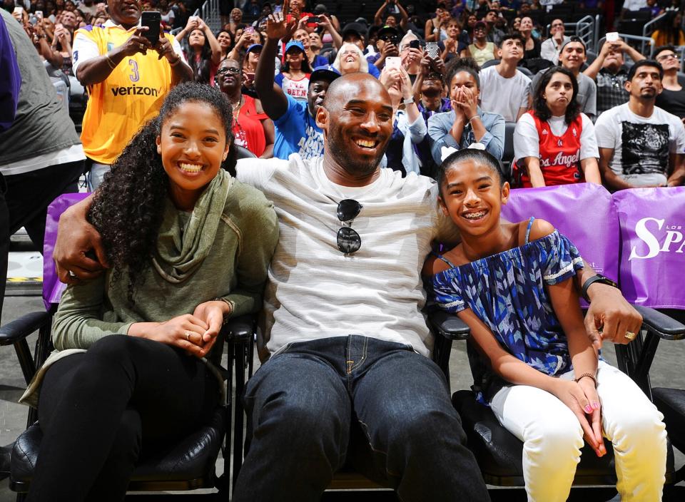 Dad had an arm around each of his older daughters at a 2017 Los Angeles Sparks WNBA game.