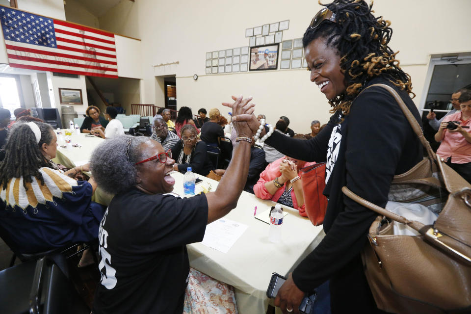 In this Aug. 24, 2018 photo, Cassandra Overton Welchlin, cofounder of the Mississippi Women's Economic Security, right, gives Betty L. Petty, of the Sunflower County Parents and Students United, a "high five" during a meeting at the MACE headquarters of Mississippi Delta grassroots organizers and the Black Voters Matter Fund field team members, as part of a bus tour of the Delta. The parties interacted in an attempt to raise interest and excitement for the upcoming election, document the campaigning in locales with important upcoming races where black turnout will be key and to expose traveling national media to the work being led by the mostly women grassroots leaders. (AP Photo/Rogelio V. Solis)