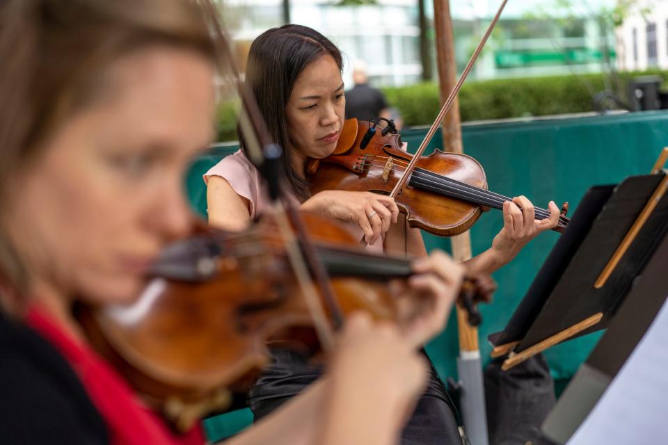 The Detroit Symphony Orchestra violinists Eun Park Lee, center, and Rachel Harding Klaus play in a quartet with other members while previewing the upcoming season with a performance at the beach in Campus Martius Park in Detroit on Friday, September 8, 2023.