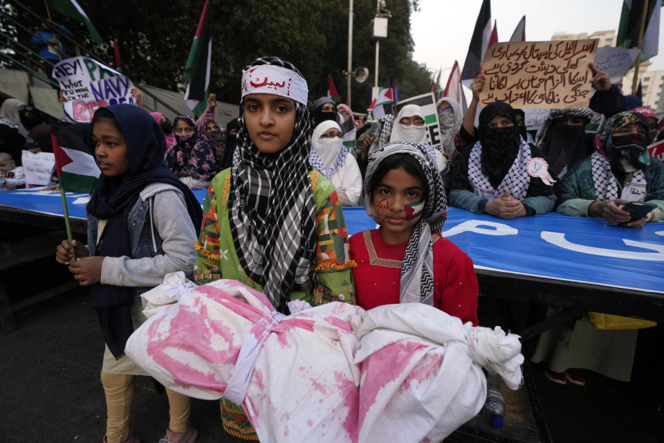 Supporters of Jamaat-e-Islami carry mock coffin during a protest against Israeli airstrikes and to show solidarity with Palestinian people living in Gaza, in Karachi, Pakistan, Sunday, Jan. 14, 2024. (AP Photo/Fareed Khan)