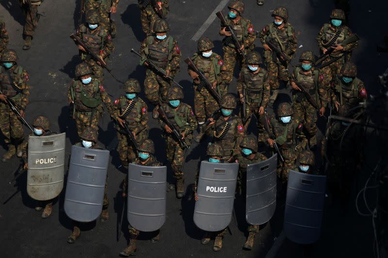 Myanmar soldiers walk along a street during a protest against the military coup in Yangon