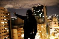 A "pichador", a graffiti artist who tags buildings and landmarks with angular, runic fonts, poses for a photograph on the roof of an apartment building before tagging a wall with his personal signature, called "pichacao", in Sao Paulo, Brazil, April 18, 2017. REUTERS/Nacho Doce