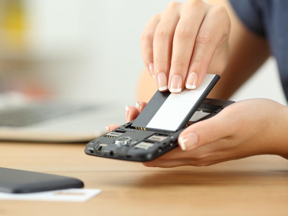 Woman inserting a new battery into an Android phone