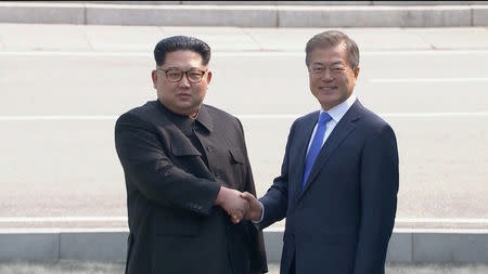 North Korean leader Kim Jong Un shakes hands with South Korean President Moon Jae-in as both of them arrive for the inter-Korean summit at the truce village of Panmunjom, in this still frame taken from video, South Korea April 27, 2018. Host Broadcaster via REUTERS TV