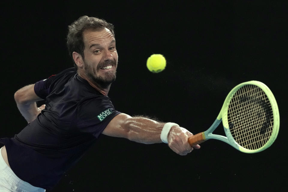 Richard Gasquet of France plays a backhand return to Carlos Alcaraz of Spain during their first round match at the Australian Open tennis championships at Melbourne Park, Melbourne, Australia, Tuesday, Jan. 16, 2024. (AP Photo/Andy Wong)