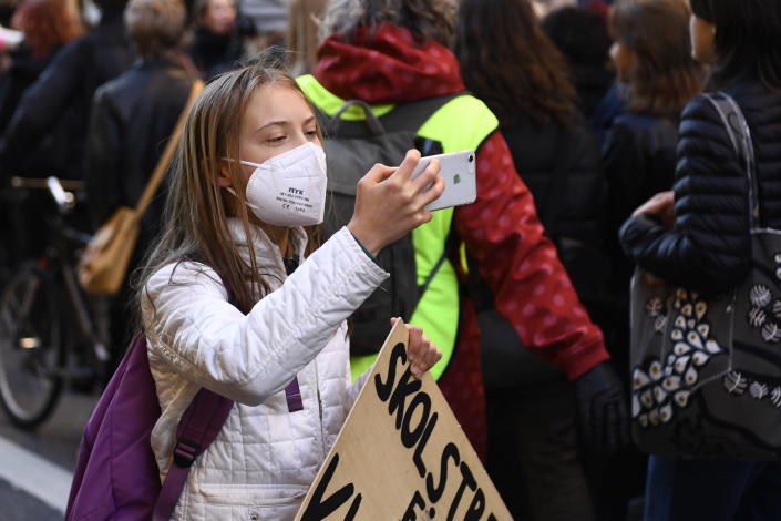 Activist Greta Thunberg takes a picture during a "global climate strike" demonstration, organized by Fridays For Future in central Stockholm, Friday, Oct. 22, 2021. (Erik Simander/TT via AP)