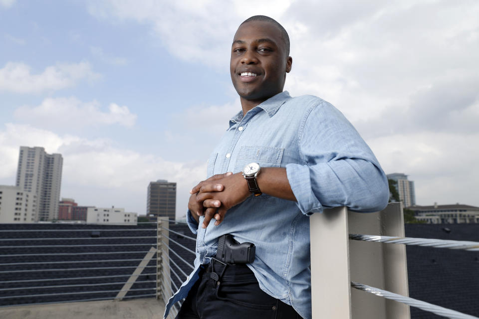 Charles Blain, a new gun owner, poses with his holstered 9mm Glock 43 handgun, Monday, May 3, 2021, on the parking garage of his apartment complex in Houston. Blain also owns a shotgun and is currently completing his concealed carry license requirements to carry the handgun. Blain, who describes himself as a conservative, says "pandemic-related unemployment crime" and repeated calls over the past year to release hundreds of jail inmates because of soaring COVID-19 infections pushed him to buy. (AP Photo/Michael Wyke)