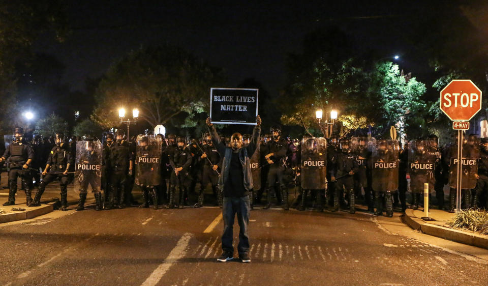 A Black Lives Matter protester stands in front of St. Louis Police Department officers equipped with riot gear on Sept. 15, 2017. (Photo: Lawrence Bryant / Reuters)