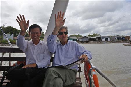 U.S. Secretary of State John Kerry and Dr. Dang Kieu Nhan (L) wave goodbye after Kerry spoke in Tan An Tay along the Mekong River Delta December 15, 2013. REUTERS/Brian Snyder