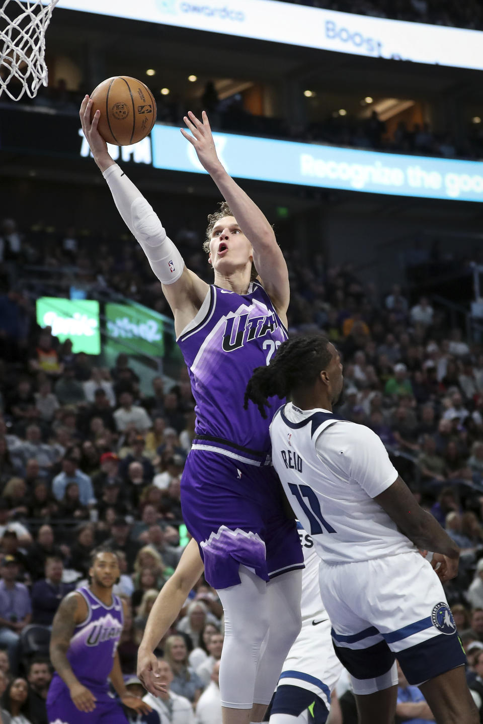 Utah Jazz forward Lauri Markkanen, top, shoots over Minnesota Timberwolves center Naz Reid (11) during the first half of an NBA basketball game Monday, March 18, 2024, in Salt Lake City. (AP Photo/Adam Fondren)