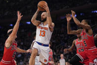 New York Knicks guard Evan Fournier (13) looks to move the ball around Chicago Bulls guard Alex Caruso (6) and forward Derrick Jones Jr. (5) in the first half of an NBA basketball game, Thursday, Dec. 2, 2021, at Madison Square Garden in New York. (AP Photo/Mary Altaffer)