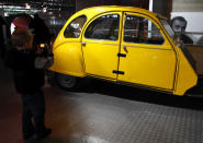 A boy takes a photograph of a Citroen 2CV, which is believed to be the only 1 of 6 remaining from the filming of the 1981 Bond film "For Your Eyes Only" on display at the opening of a press preview of the Bond in Motion exhibition at the Beaulieu National Motor Museum at Brockenhurst in the southern English county of Hampshire on January 15, 2012. The Bond in Motion exhbition features fifty original iconic vehicles used in the James Bond films to celebrate fifty years of 007 and will open to the public from January 17. AFP PHOTO/ JUSTIN TALLIS