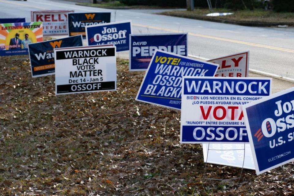 Signs line a road at a Gwinnett County voting location on January 5, 2021 in Atlanta, Georgia. Polls have opened across Georgia in the two runoff elections, pitting incumbents Sen. David Perdue (R-GA) and Sen. Kelly Loeffler (R-GA) against Democratic candidates Rev. Raphael Warnock and Jon Ossoff. (Photo by Megan Varner/Getty Images)